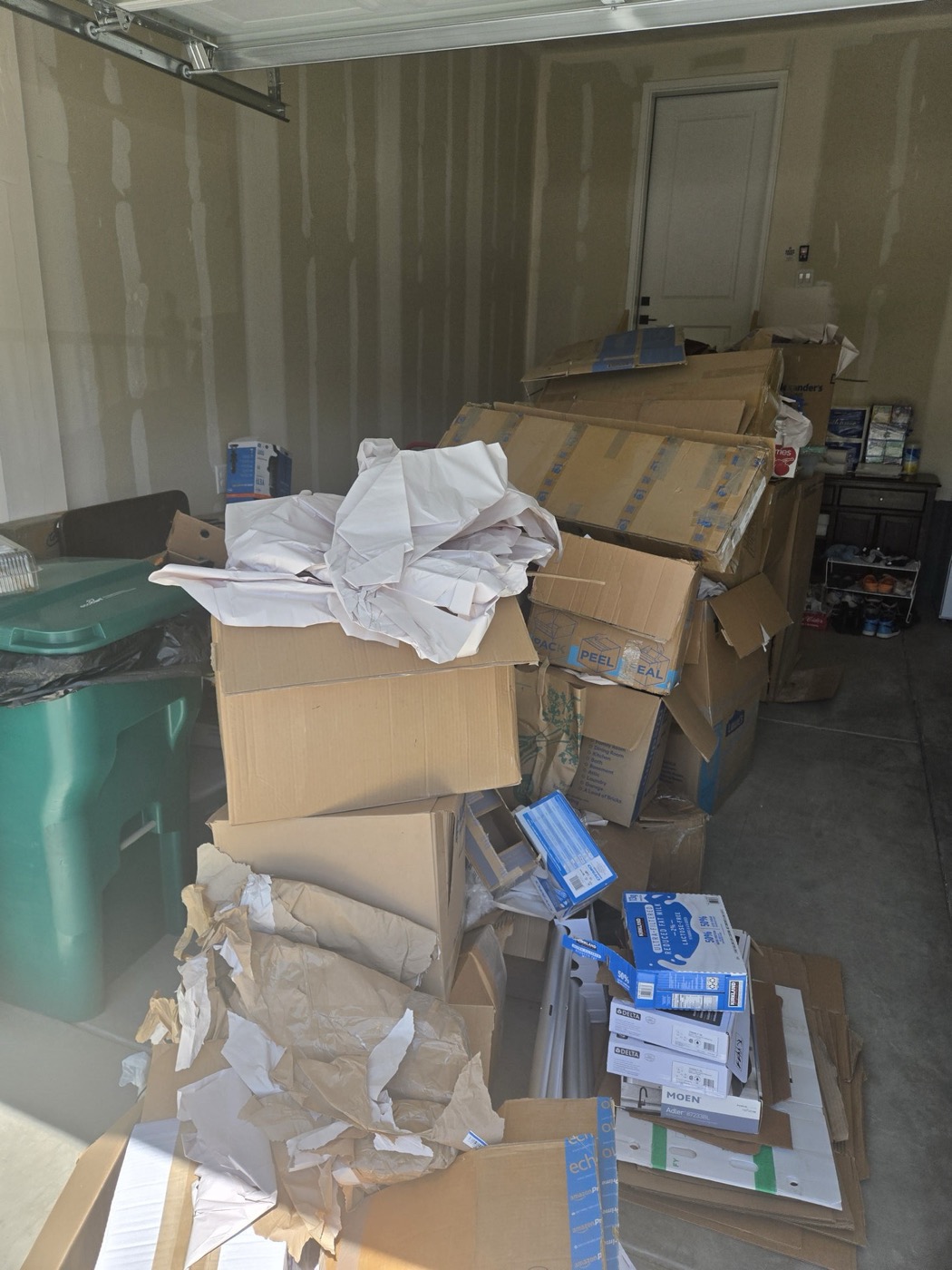 Garage packed with moving boxes and packing paper before a cleanout